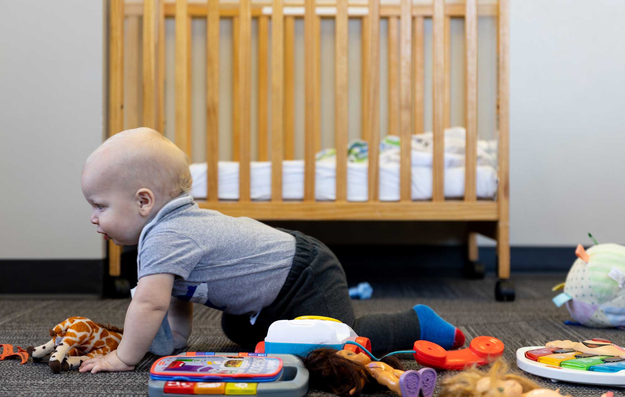 infant crawling with toys
