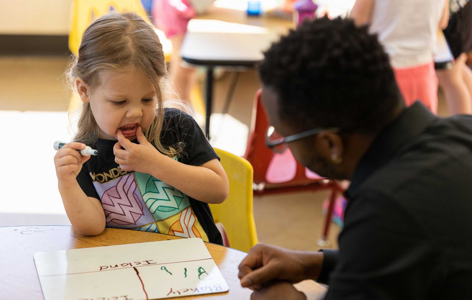 pre-K child and teacher working on letters