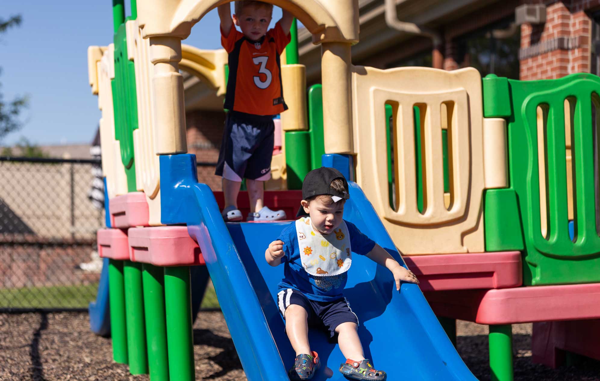 toddlers going down a slide on the playground